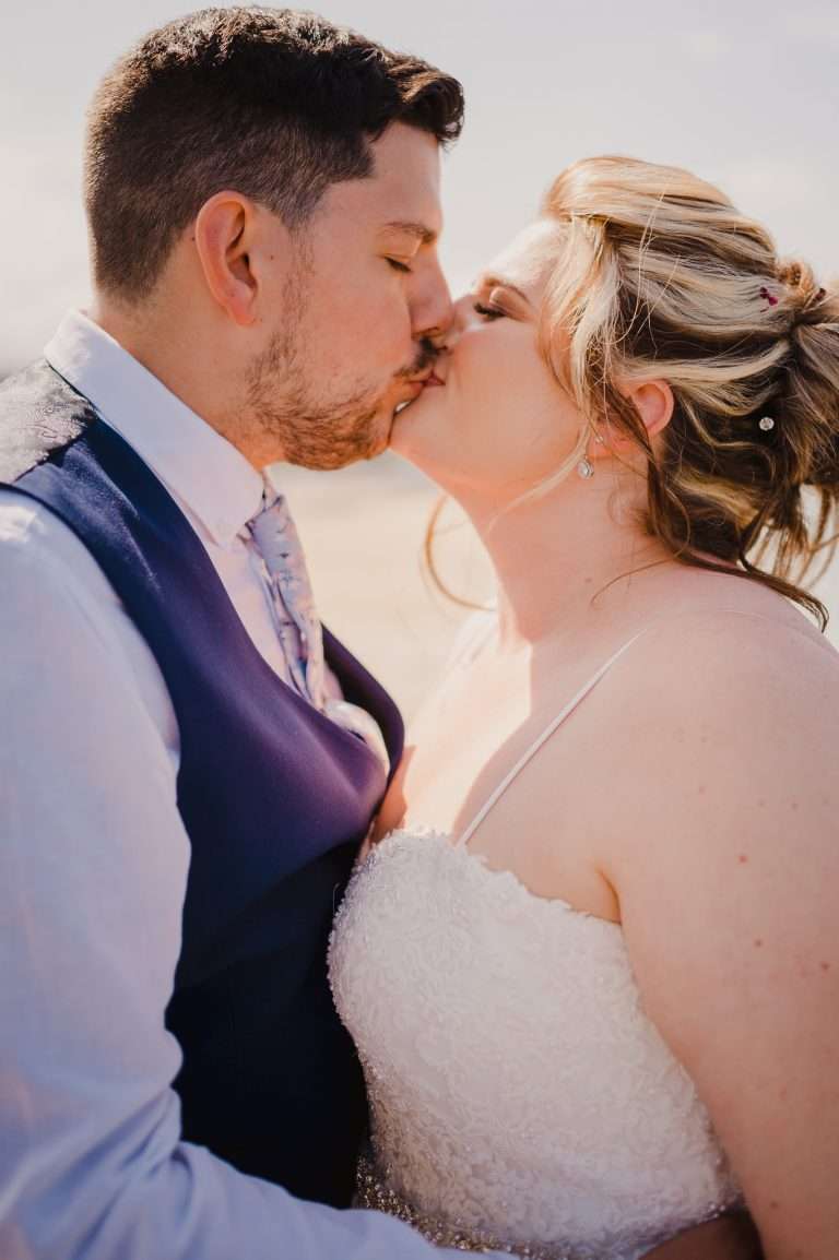Couple Kiss on the beach for their St Ives Wedding