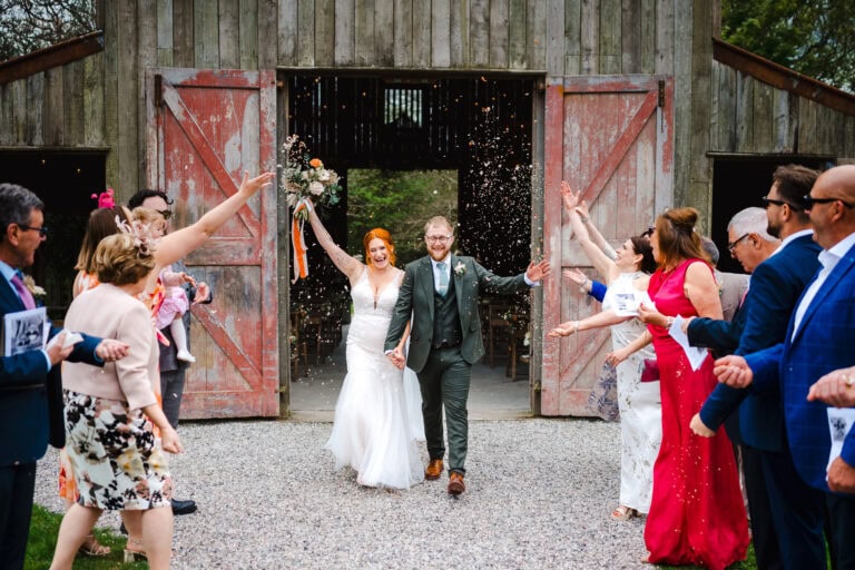 Walking down the confetti aisle outside the wedding barn at Nancarrow -How To Look Your Best In Wedding Photos