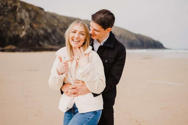 Loving her engagement ring during a Cornwall Proposal at Holywell Bay