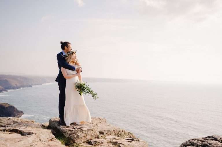 Wedding Couple hugging and staring out at the Cornish Sea
