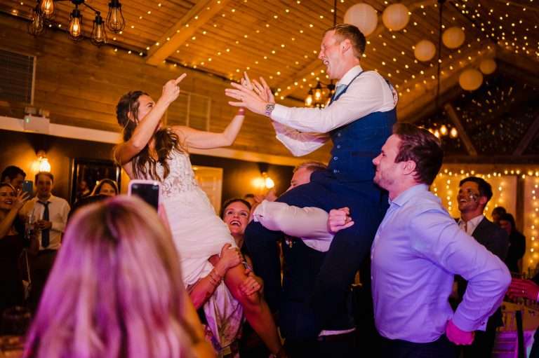 Wedding couple being carried at wedding reception at Chycara - Wedding DJ or Wedding Band? Which is better?