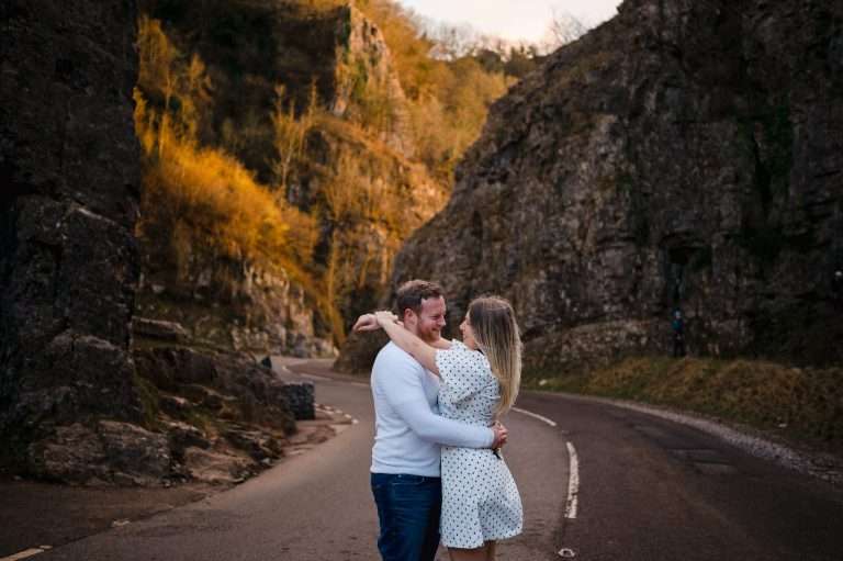 Happy couple cuddle at the breath taking Cheddar Gorge - Engaged? A Long or A Short Engagement: Which One Is Right For You?