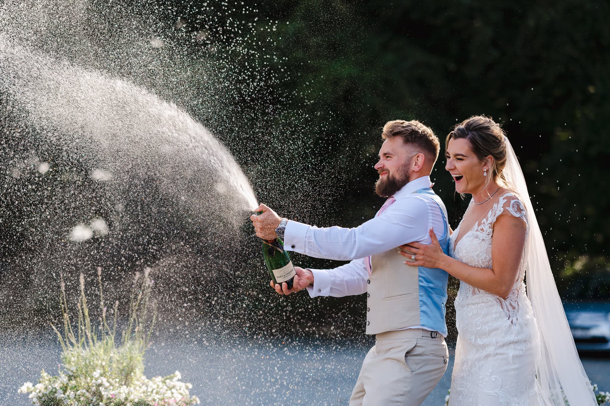 Bride and groom making champagne spray