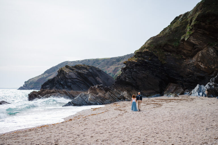 Wedding couple walking along beach after getting married in Cornwall - 25 Creative Wedding Planning Tips To Plan Your Dream Wedding