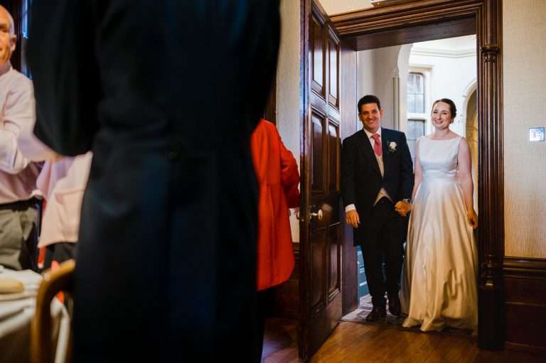 Wedding Couple walk into wedding reception room as the guests stand up - Your Ultimate Guide To Craft Your Wedding Day Timeline Part Two