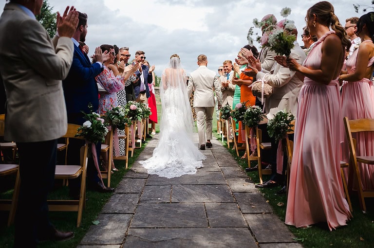 Walking back down the wedding aisle as the dress train follows 