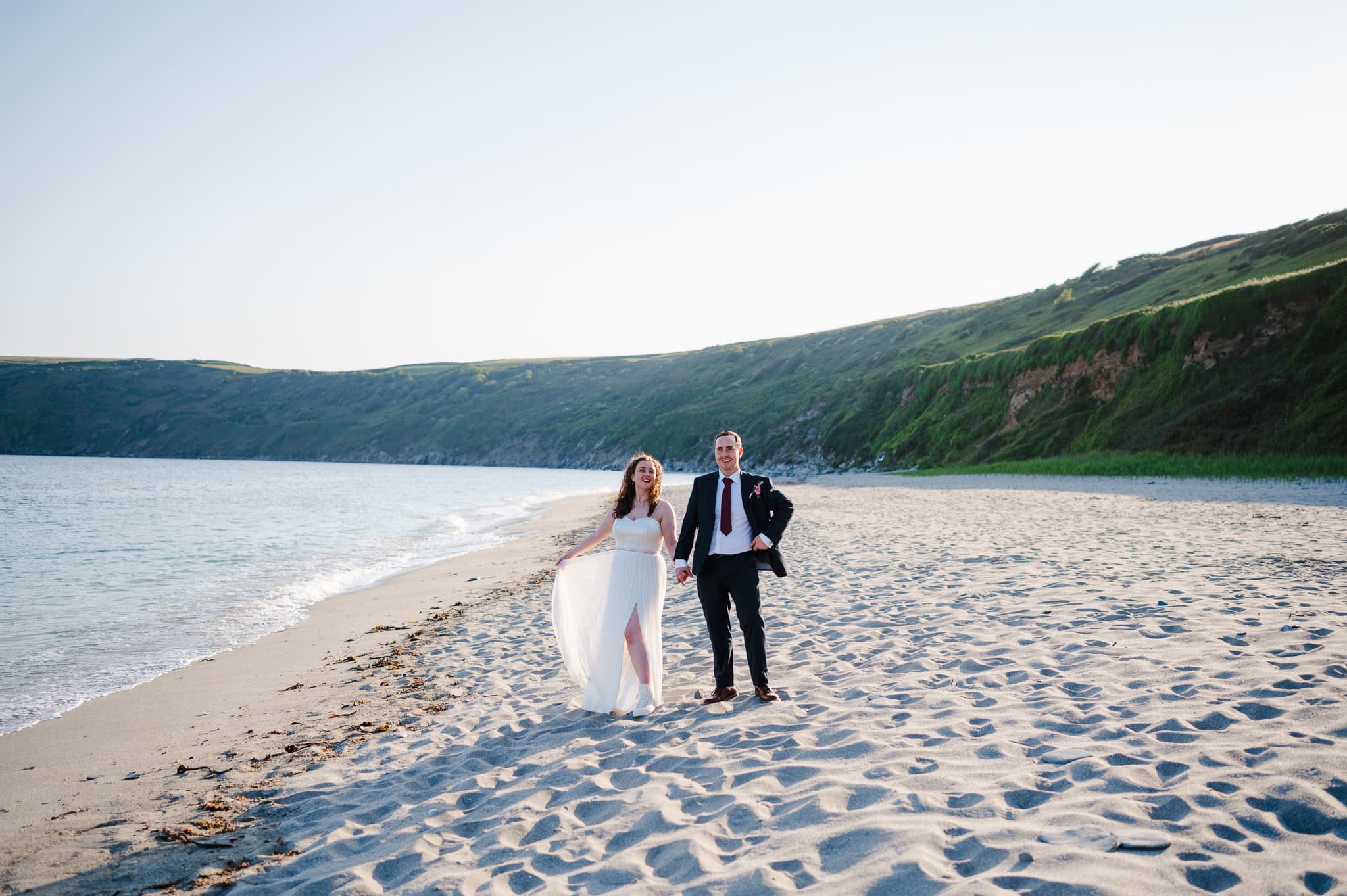 Wedding couple just married headed to a beach in Cornwall