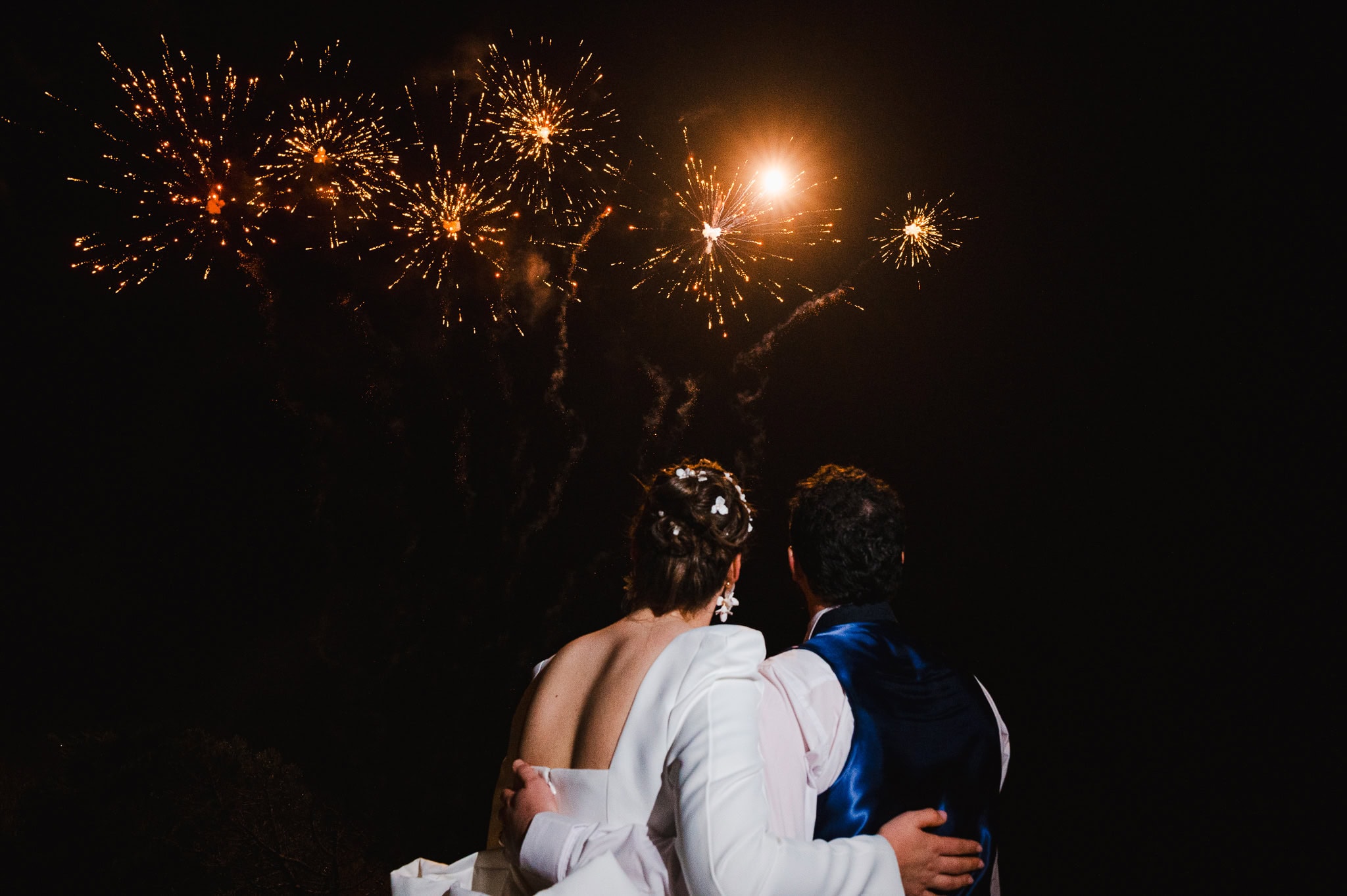 Wedding day fireworks exploding in the dark sky as the happy couple look out watching the firework display for a Polurrian Hotel Wedding