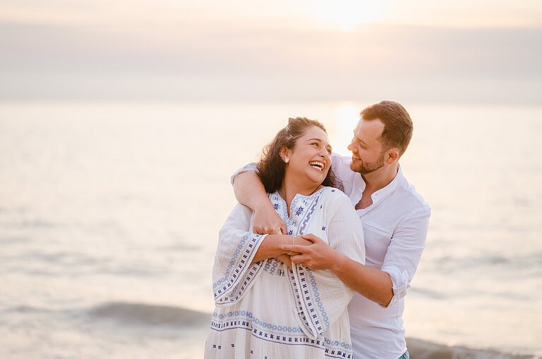 The sunsets behind the couple as they can't containt their happieness during their engagement photo shoot by Cornwall Engagement Photographer, Jake Timms Photography