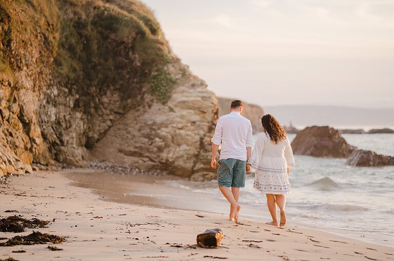 Beach walks hand in hand as the sunsets over Godrevy, Cornwall, by Cornwall engagement photographer, Jake Timms Photography