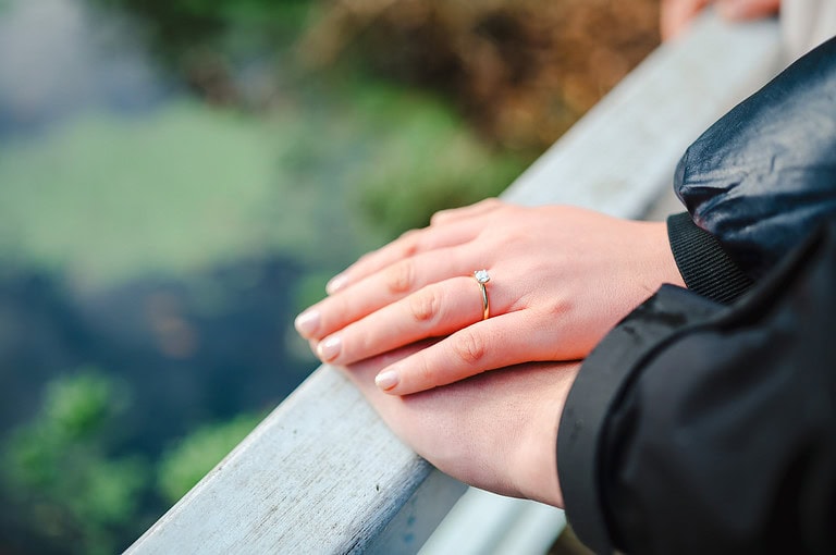 Showing off the engagment ring as they place their hands on top of each other by Cornwall Engagement Photographer, Jake Timms Phootgraphy