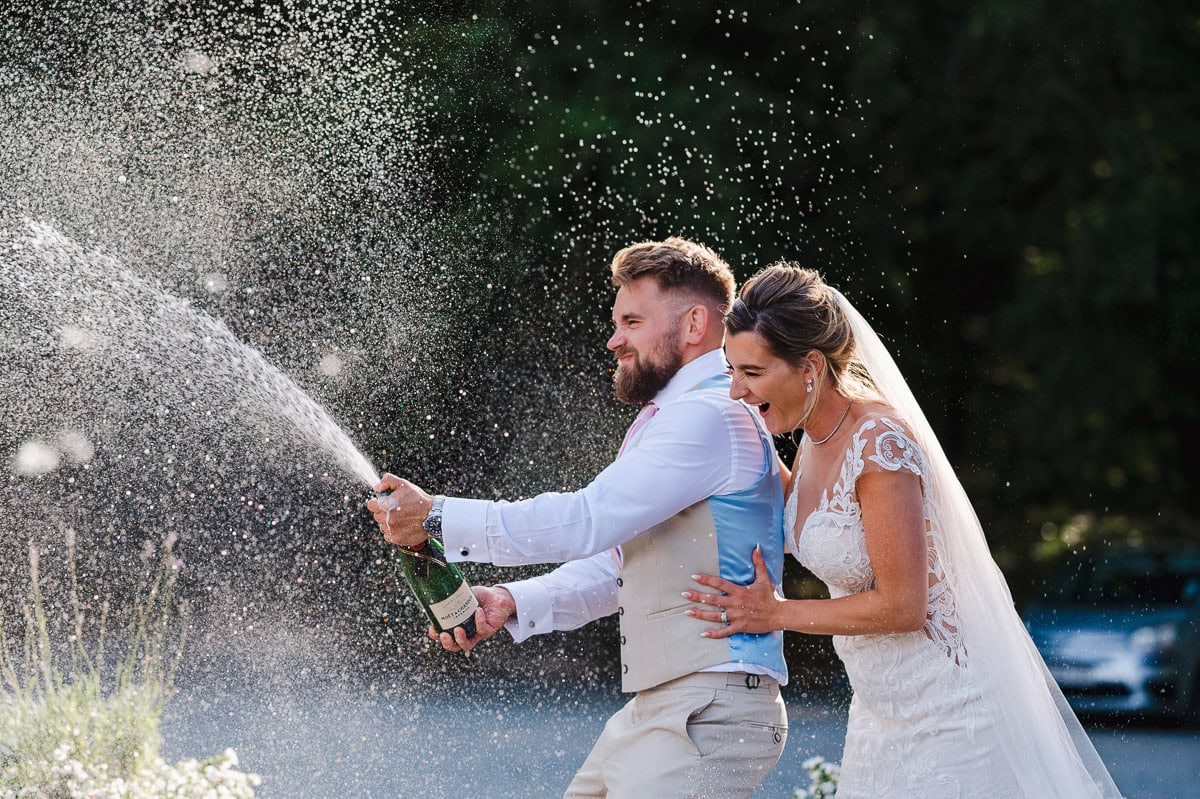it's time to pop the champagne as the happy couple celebrate getting married in Cornwall - Wedding Portfolio