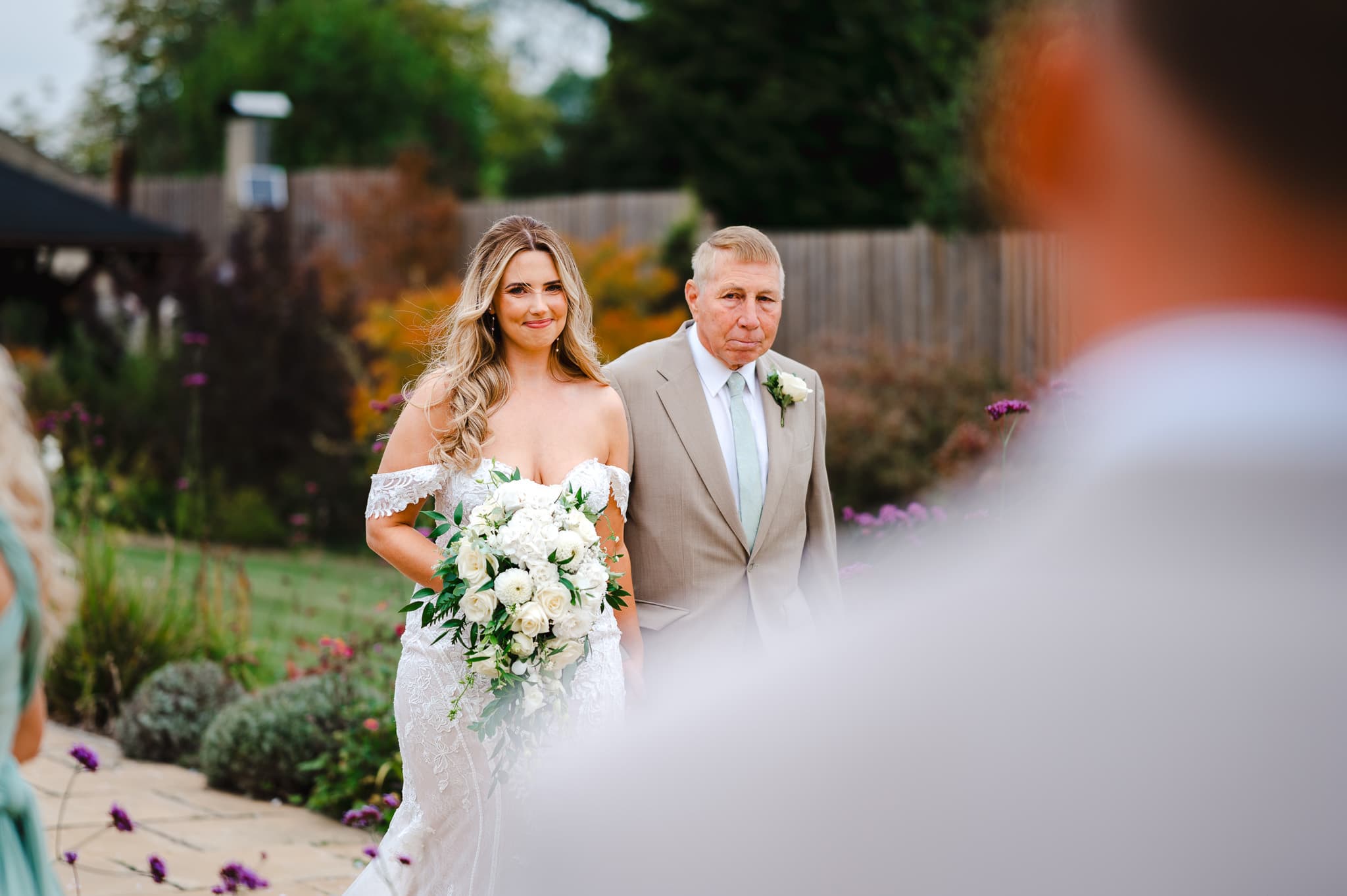 The bride walks down the aisle and sees the groom in the distance at The Pear Tree - Wedding Video