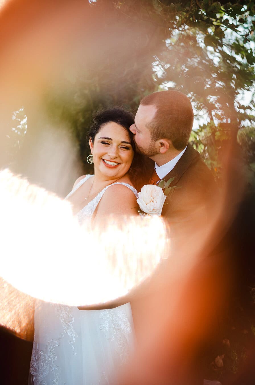 Couple wrap their arms around each other as they pose for an artistic wedding photo by Cheshire Wedding Photographer - Jake Timms Photography